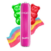 Pink HQD SURV Vape mit rotem und grünem Gummibärchen und buntem Regenbogenhintergrund